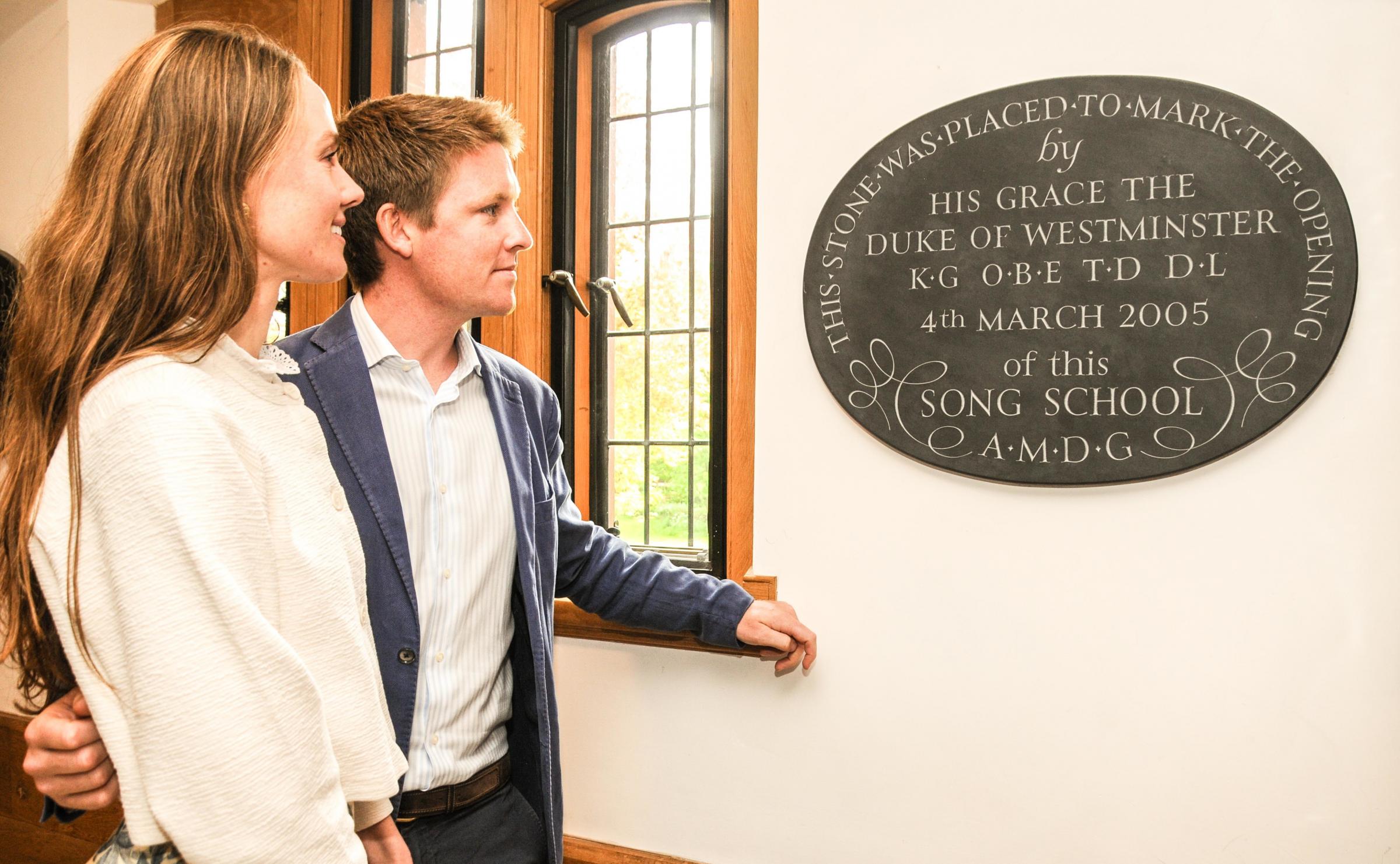 Hugh Grosvenor, with Olivia Henson, view the plaque honouring the dukes father when he opened the cathedrals Song School in 2005.
