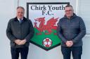 Simon Baynes MP with Mark Evans, Chairman of Chirk Youth FC, in front of the Chirk Youth FC Club Logo at Chirk AAA