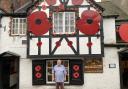The Fox landlord Mick Burton outside his poppy decorated pub in Church Street.