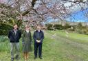 Simon Baynes MP by a blossom tree with General Manager Lizzie Champion and  Head Gardener David Lock at Chirk Castle