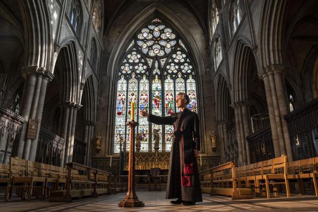 Border Counties Advertizer: Very Reverend John Dobson Dean of Ripon lights a candle to mark the second anniversary of the first national coronavirus lockdown at Ripon Cathedral, North Yorkshire, ahead of the National Day of Reflection on Wednesday (PA)