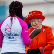Queen Elizabeth II talks to the first baton bearer, British parasport athlete Kadeena Cox, at the launch of the Queen's Baton Relay for Birmingham 2022 - the XXII Commonwealth Games, on the forecourt of Buckingham Palace in London. Picture date: