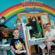 With the two new interactive gaming carts are, from left, Jess Miree from TheRockinR; Freddie Evans, aged 5 a patient on Alice Ward; Polly Brown, Health Play Specialist; Heather Thomas-Bache, Head of Fundraising, Communications and Volunteers for the