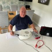 Volunteer Alec Weeks using the Portable Appliance Tester.