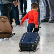 File photo dated 26/08/2023 of a young boy pulling a suitcase as refugees arrive from Afghanistan at Heathrow Airport, London.