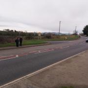 Two school boys wait to cross the A483 at Llynclys Crossroads.