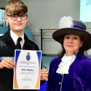 Alfie is pictured receiving his award from the High Sheriff of Shropshire, Mandy Thorn MBE DL.