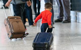 File photo dated 26/08/2023 of a young boy pulling a suitcase as refugees arrive from Afghanistan at Heathrow Airport, London.